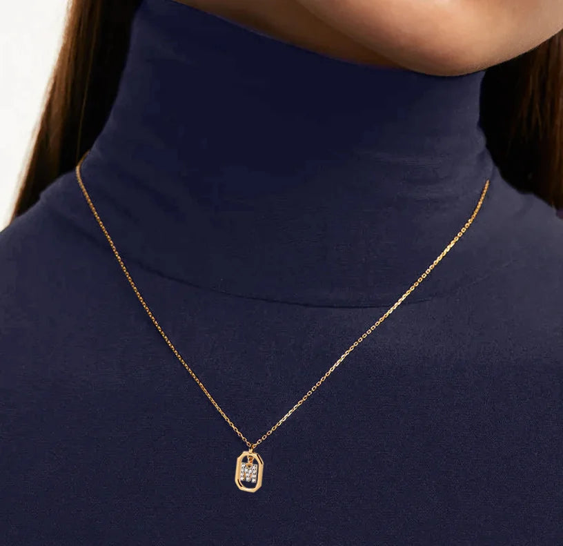 A diamond M necklace featuring a sparkling letter “M” pendant adorned with diamonds on a delicate chain, adding a luxurious and personalized touch.