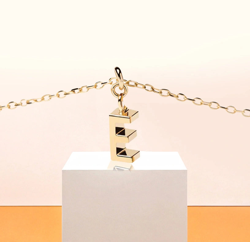 Gold dainty initial necklace with letter E pendant on an adjustable anchor chain, finished with a lobster clasp for a personalized and elegant look.