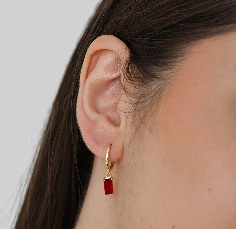 Lightweight 14mm gold hoop earrings with precision-cut fiery garnet stone charm, suspended gracefully.