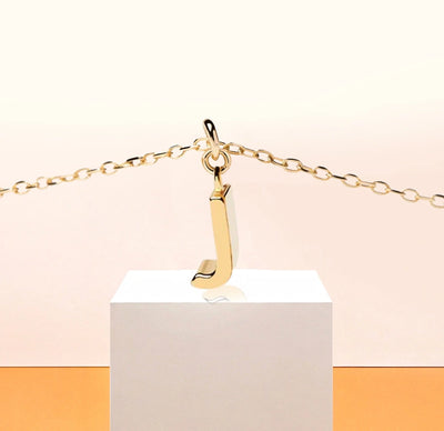 Chic dainty necklace with a gold letter J pendant, capturing understated sparkle on an adjustable anchor chain with a secure clasp.