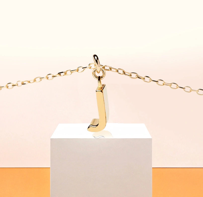 Chic dainty necklace with a gold letter J pendant, capturing understated sparkle on an adjustable anchor chain with a secure clasp.