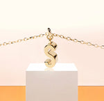 Delicate gold necklace with letter S pendant, glowing subtly on a fine adjustable anchor chain, perfect for a personalized minimalist look.
