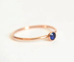 Minimalist blue sapphire engagement ring with solitaire gemstone on a delicate gold band
