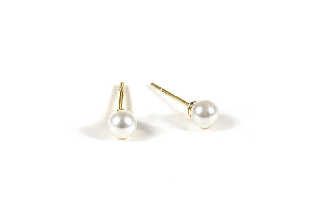 Tiny pearl stud earrings featuring small, lustrous pearls set on delicate posts, adding a subtle and elegant touch to any outfit.