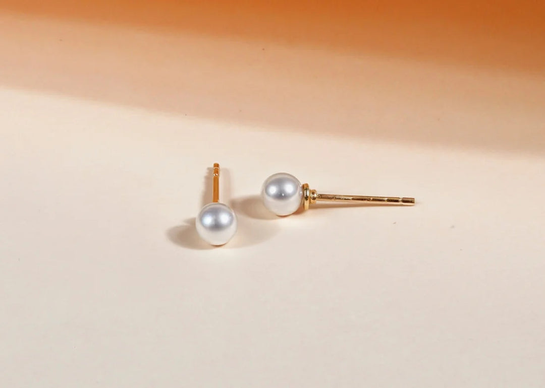 Women’s pearl stud earrings featuring classic round pearls set on delicate posts, offering a timeless and elegant accessory for any outfit.
