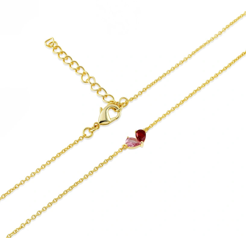 Romantic heart-inspired necklace with pink tourmaline and ruby pear cuts cradled together on a yellow gold-plated chain. 